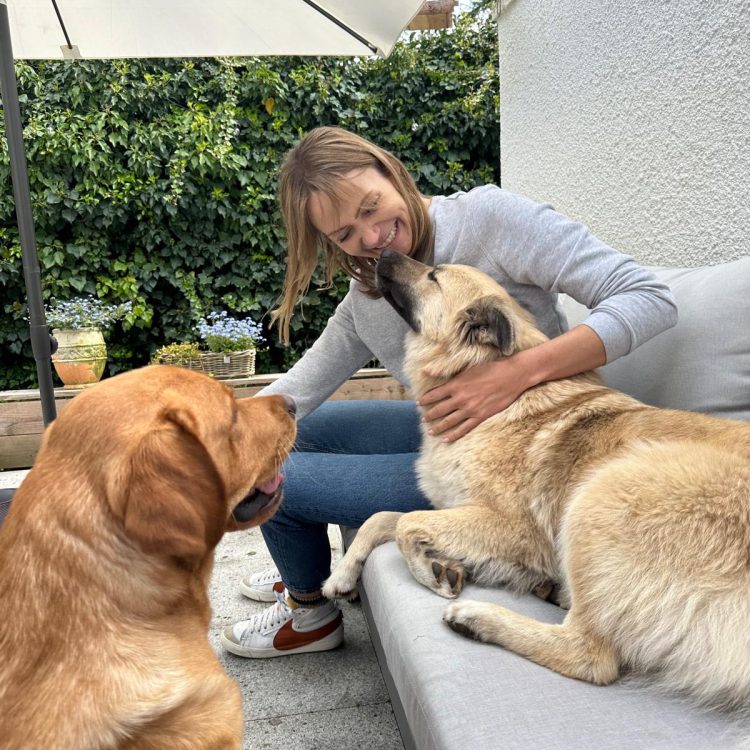 Frau mit zwei Hunden dfraußen im Sommer